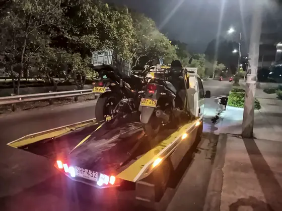 Grúa de noche con dos motos en el planchón