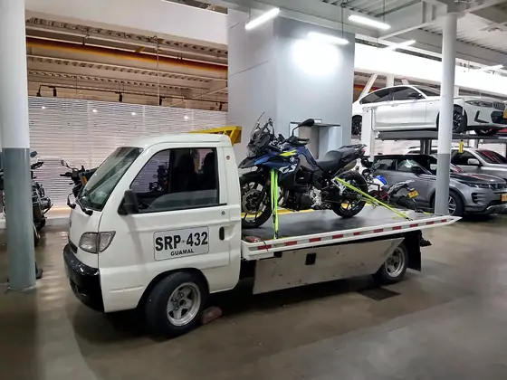 Moto de alto cilindraje asegurada en la grúa dentro de un parqueadero