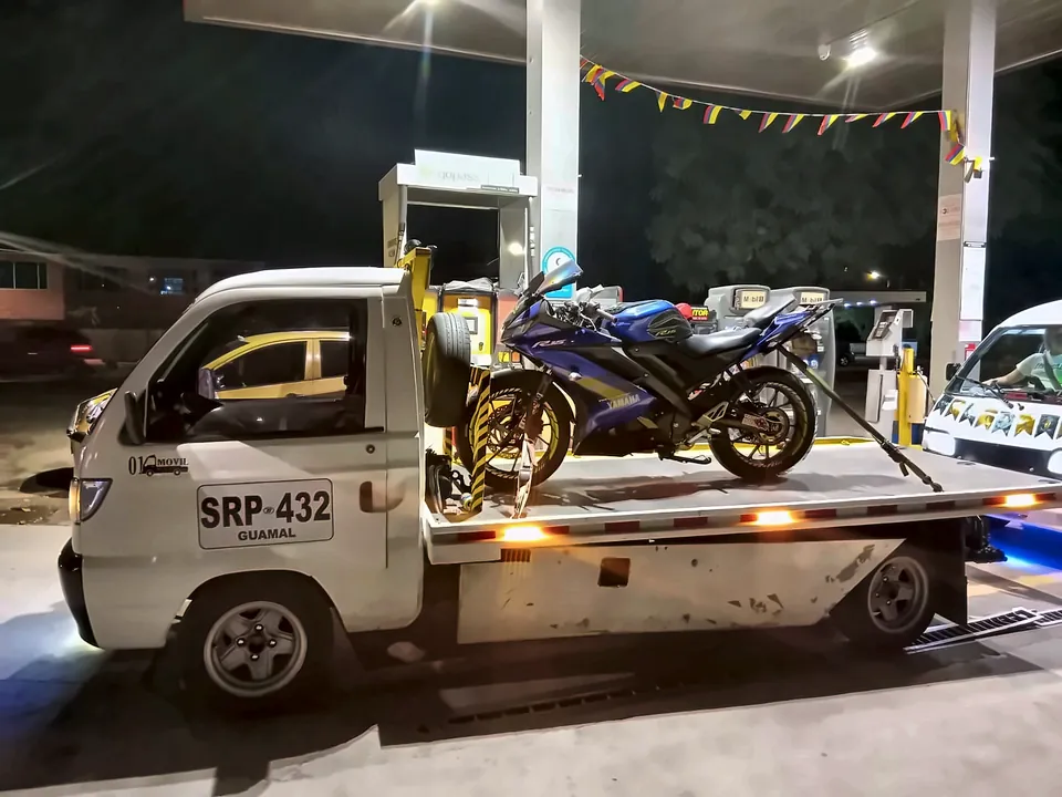 Moto deportiva azul en la grúa, de noche en una estación de servicio